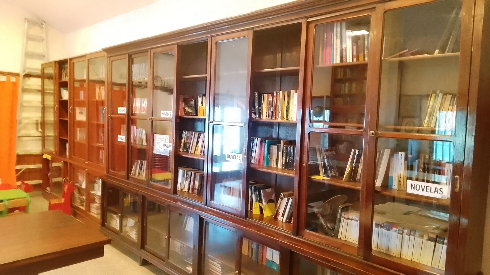 Estanterías de madera con libros de novelas en la Biblioteca Popular Encuentros