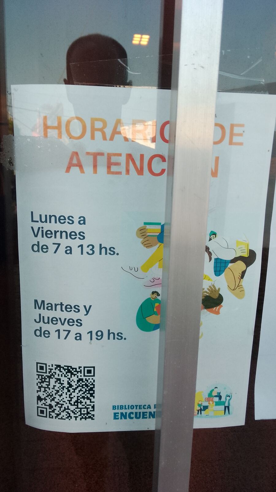 Cartel de horarios de atención en la puerta de la biblioteca